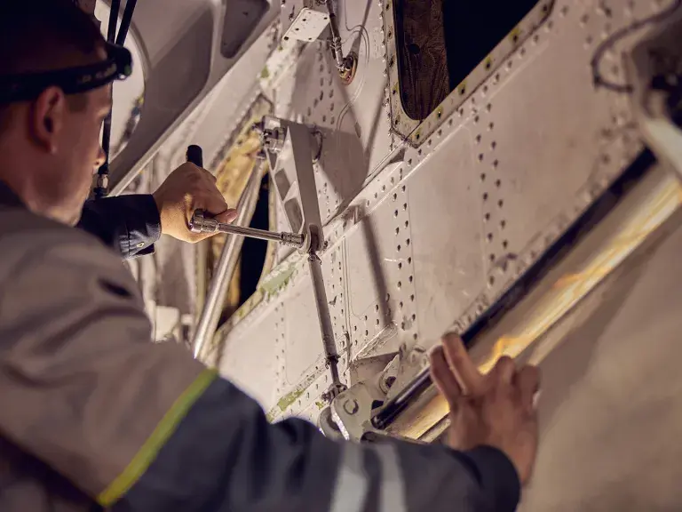Maintenance mechanic working on an airplane with aviation equipments in hands