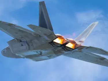 Very close tail view of a F-22 Raptor, with afterburners on and the jet stream visible behind the aircraft